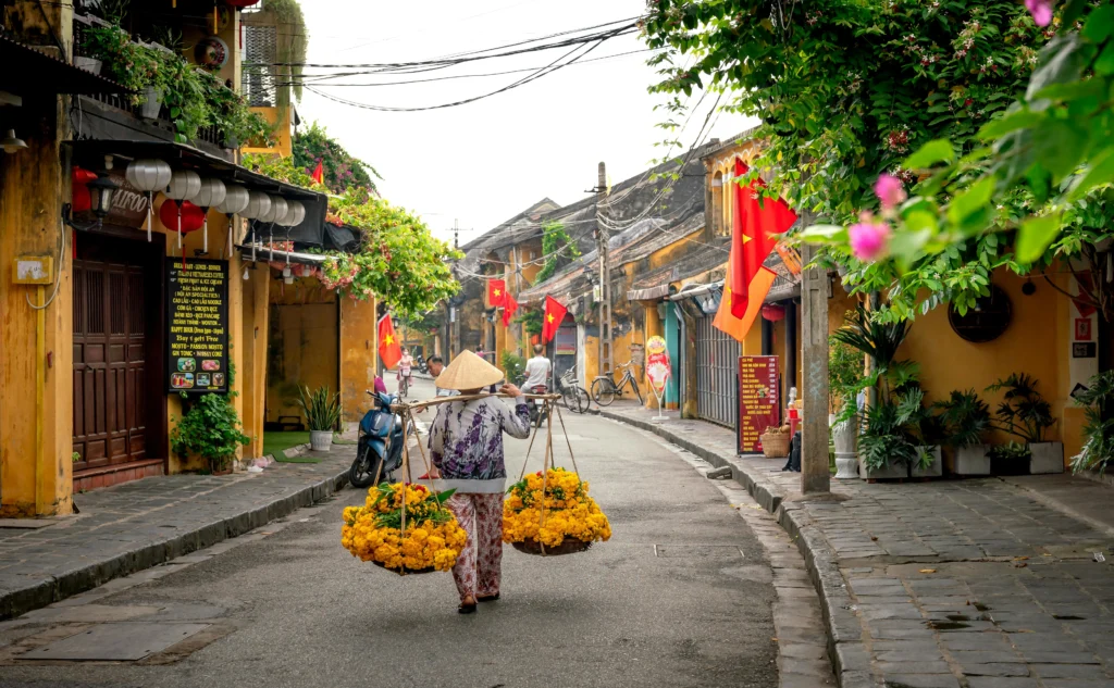 A vibrant, lantern-lit street in Hoi An Ancient Town at dusk.